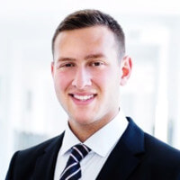 Professional headshot portrait of a business person in formal attire smiling at camera